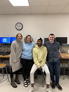 Kelly Campbell, William Kinczewski, Maria Madgalena Pereira Lopez and Rahul Ravichandran posed in a classroom